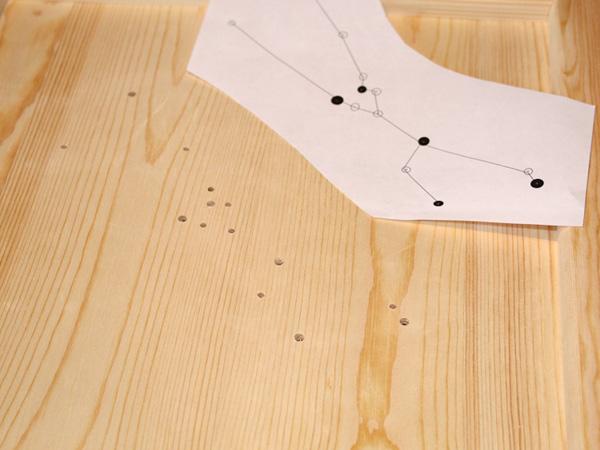 Löcher für das Sternzeichen in die Holzplatte bohren