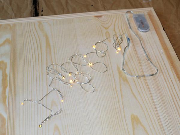 Lichterkette auf den Bilderrahmen fixeren in Form von dem Sternzeichen